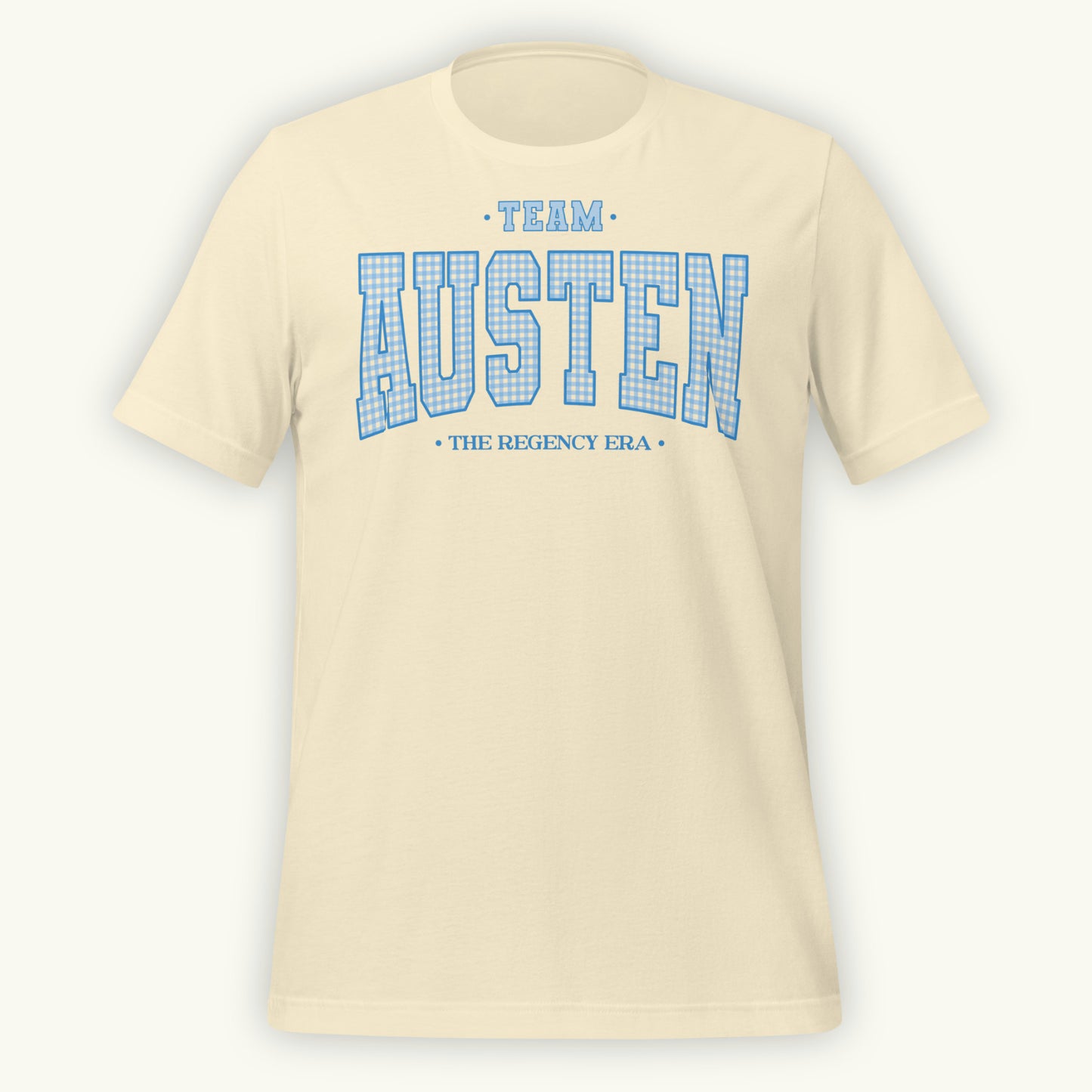 Cream colored t-shirt with 'Team Austen The Regency Era' in blue gingham style varsity text on a white background