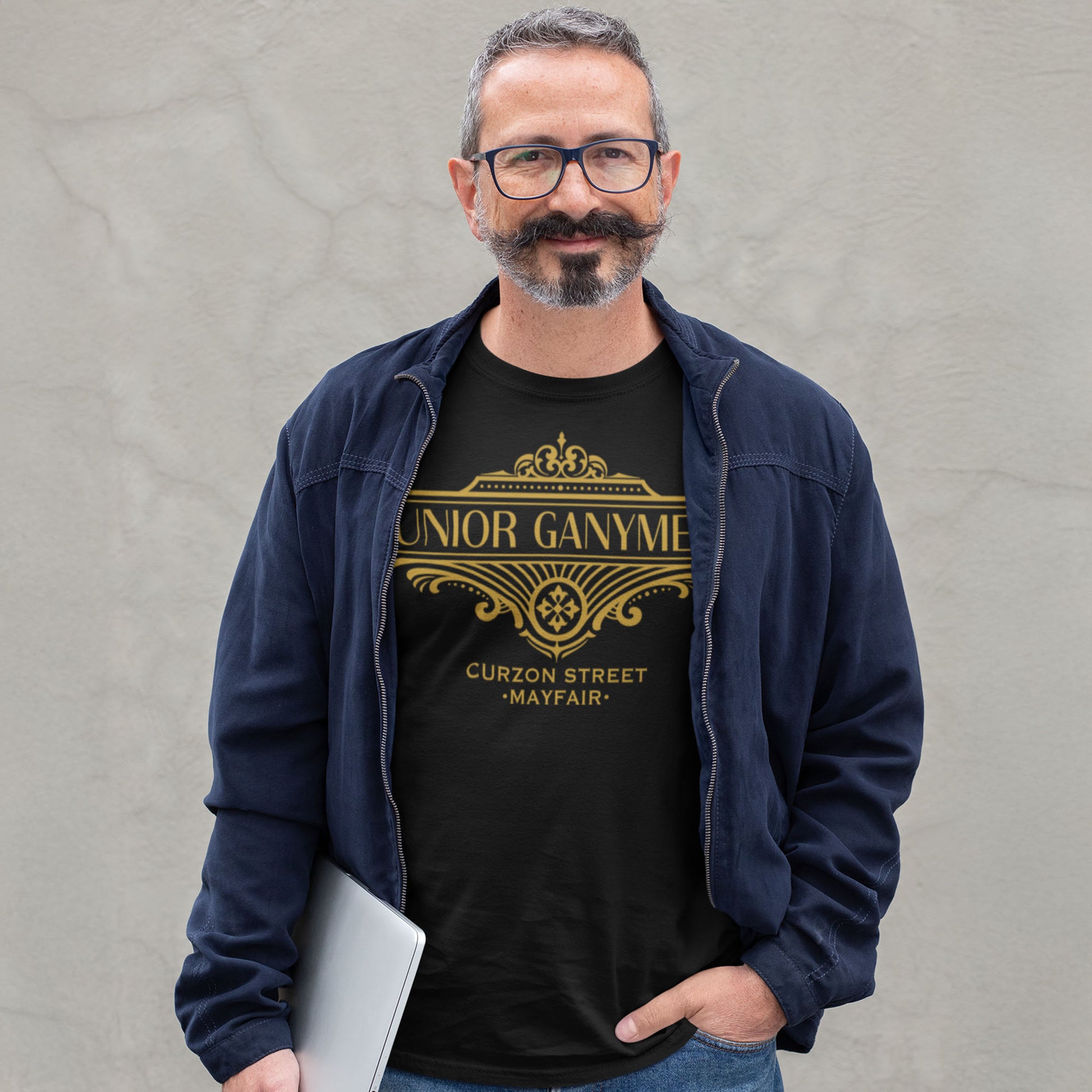 Man wearing a black t-shirt with gold text and Jeeves design, standing against a gray background