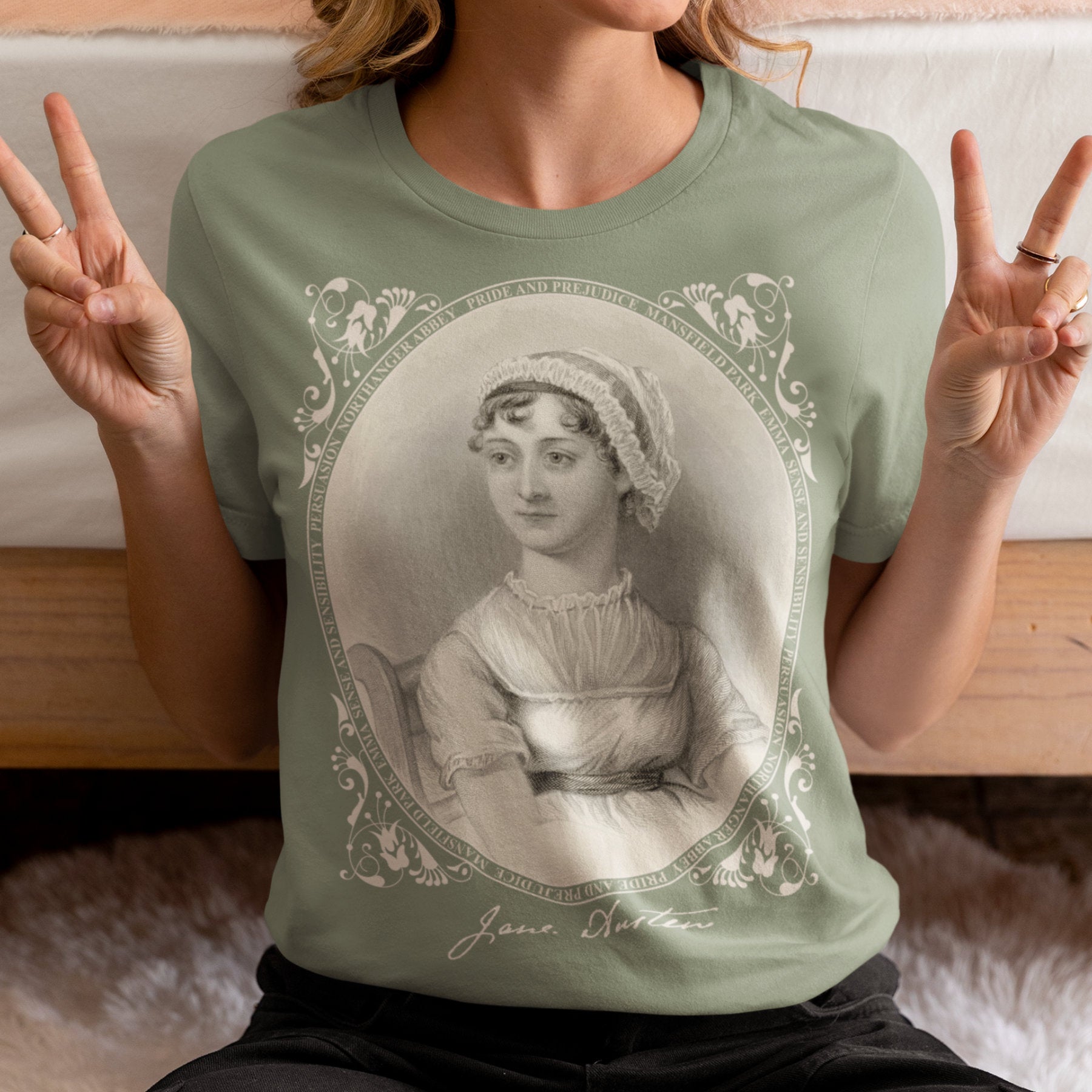 Person wearing a green t-shirt with a Jane Austen graphic, making peace signs.