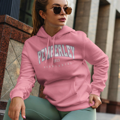 Beautiful woman wearing a pink Jane Austen hoodie with 'Pemberley' text, sitting outdoors.